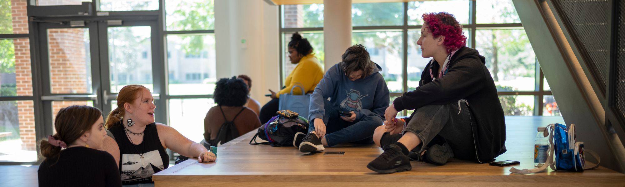 Students sitting under student union staircase.