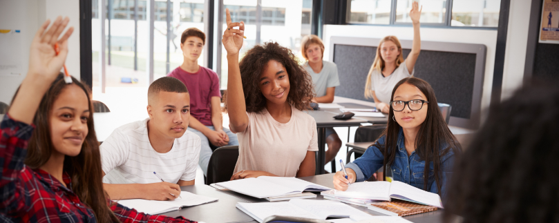 Students raising their hands in a classroom